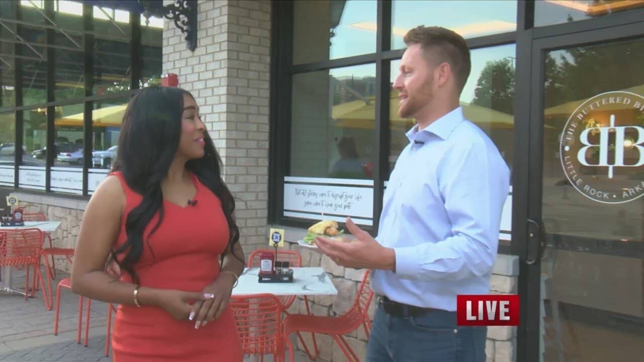 reporter interviewing Sam in front of the Buttered Biscuit