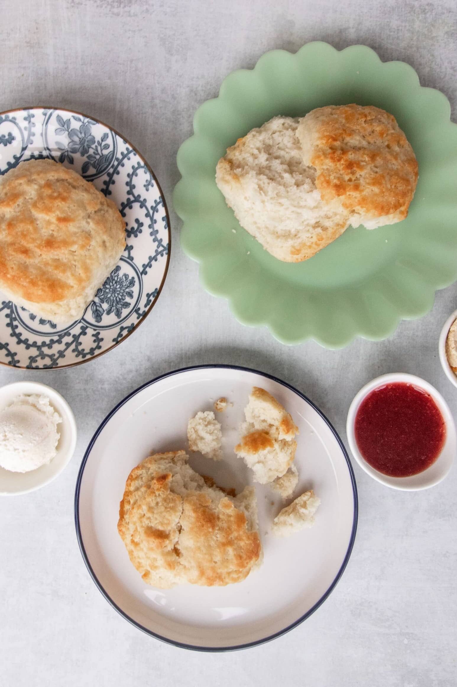 three plates of biscuits with jam and butter