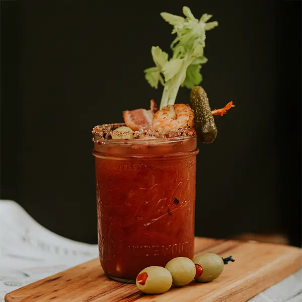 bloody mary in mason jar with celery and shrimp