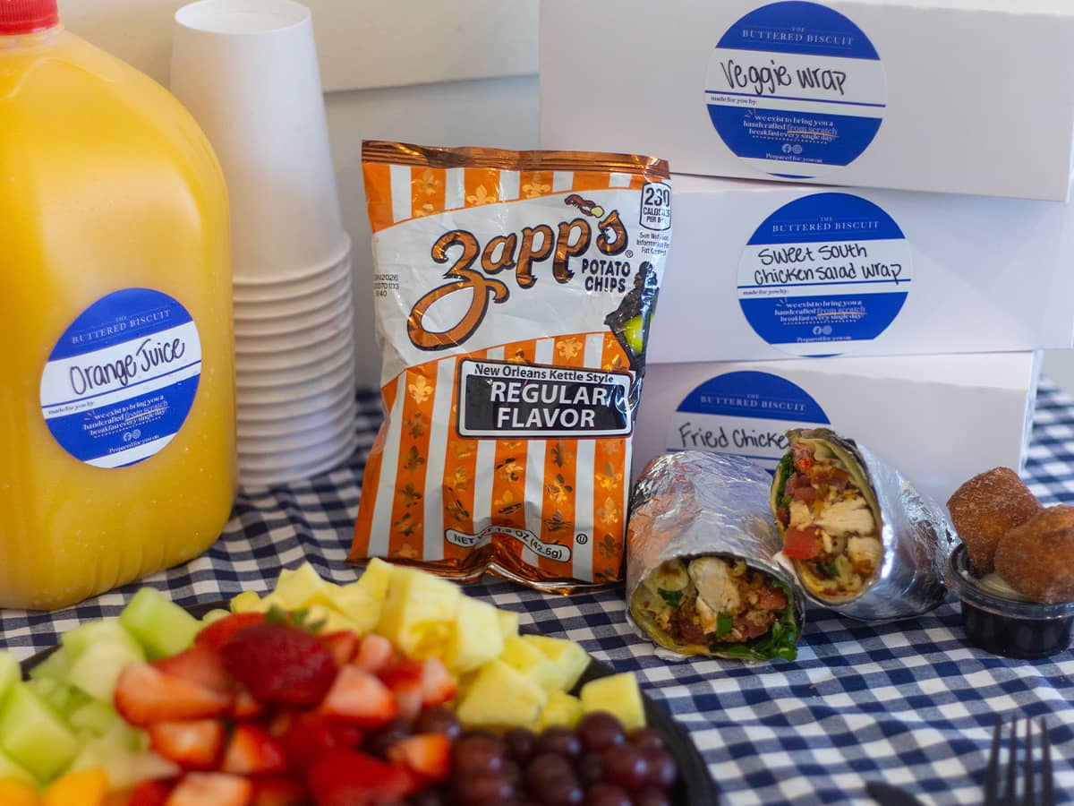 Orange juice, fruit tray, chips and sandwich wraps