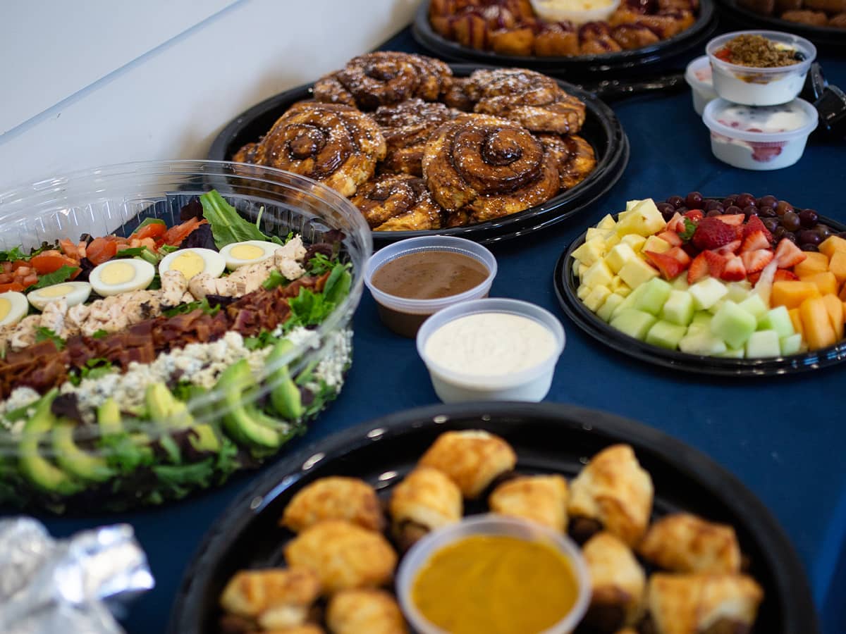 Salad, pigs in a blanket, fruit tray and cinnamon buns